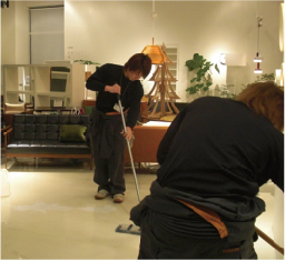 清掃会社の職員が家具店の床を清掃している写真